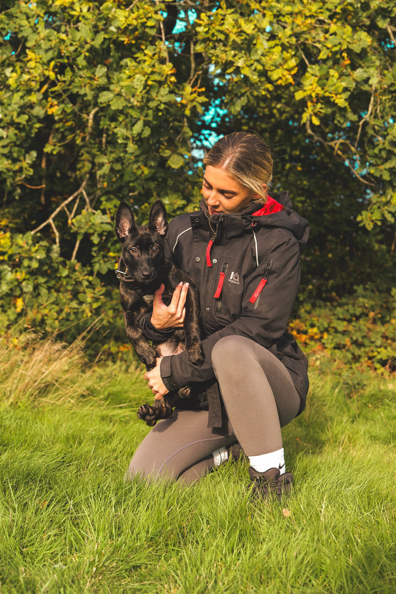 Holly holding a young Dutch Shepherd puppy